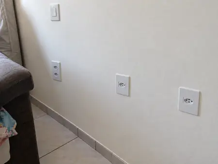 Parede com tomadas novas embutidas e espelhos alinhados