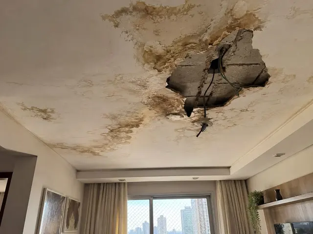 Teto com abertura e manchas de infiltração antes do reparo
