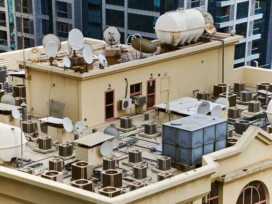 Cobertura de prédio com várias caixas d'água brancas e antenas