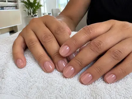 Unhas das mãos cuidadas e esmaltadas em tom natural