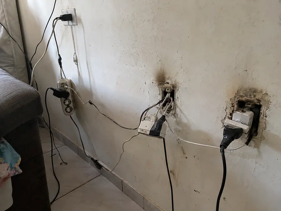 Parede com tomadas quebradas e fios expostos