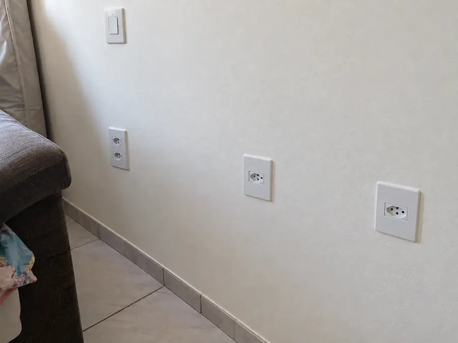 Parede com tomadas novas embutidas e espelhos alinhados
