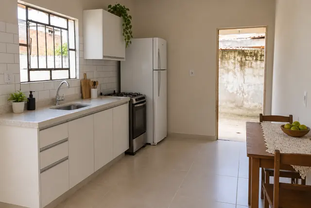 A mesma cozinha depois da reforma, com porcelanato bege, azulejo branco e bancada clara