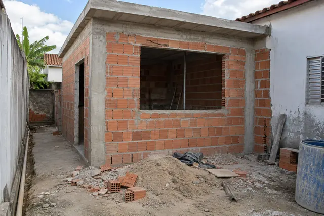 Quarto de ampliação com paredes de bloco sem reboco e laje recém-feita, em obra
